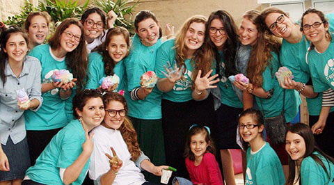 Imagem com vários voluntários do Friendship usando camisetas da ONG e sorrindo.