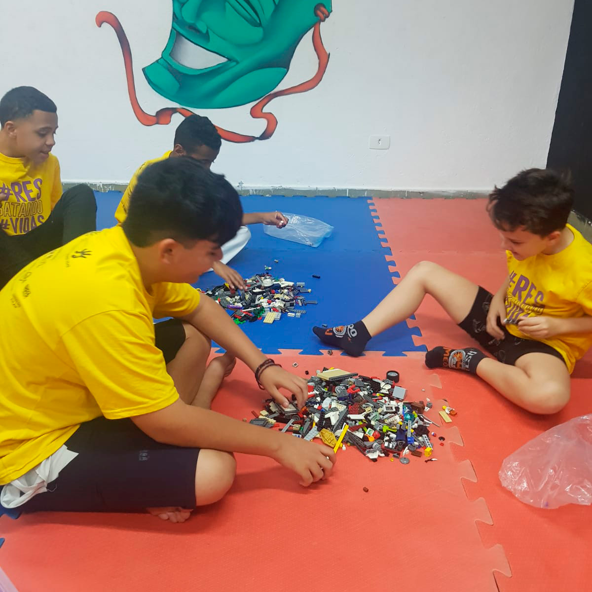 Crianças brincando com blocos de Lego, construindo e criando juntos em um ambiente divertido e colaborativo.