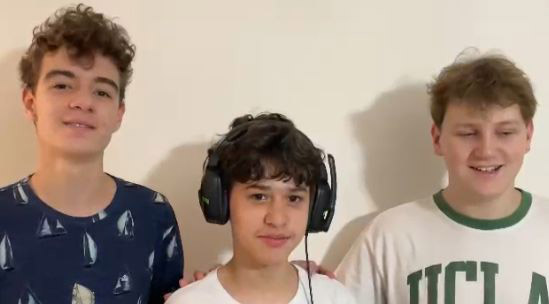 Três adolescentes sorrindo, um usa fones de ouvido